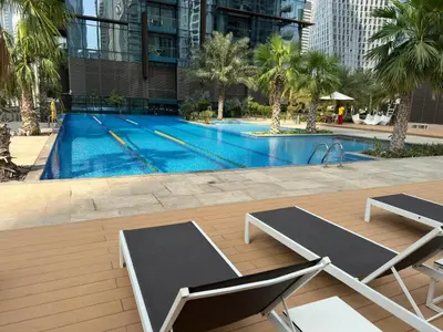 a swimming pool with two lounge chairs next to a building at 3BR Full Marina View for 8 Near The Metro! in Dubai