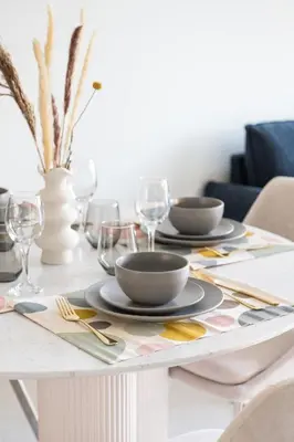 a dining room table with plates and glasses on it at Elegant 2BR in Burj Royale in Dubai