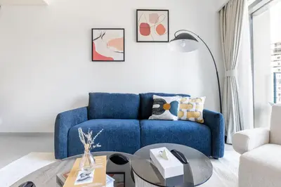 a living room with a blue couch and a table at Elegant 2BR in Burj Royale in Dubai