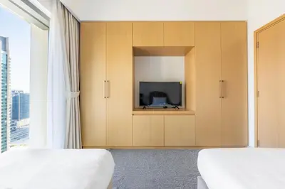 a hotel room with two beds and a tv at Elegant 2BR in Burj Royale in Dubai