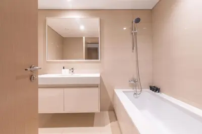 a bathroom with a sink and a tub and a mirror at Elegant 2BR in Burj Royale in Dubai