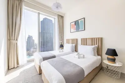 two beds in a hotel room with a large window at Luxury 3BR and Maid room Forte Tower 1 with Fountain View in Dubai