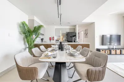 a dining room with a table and chairs at Luxury 3BR and Maid room Forte Tower 1 with Fountain View in Dubai