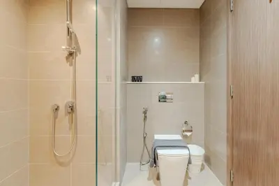 a bathroom with a toilet and a glass shower at Stunning 2BR Apt Burj Royale 10 mins walk to Dubai mall in Dubai