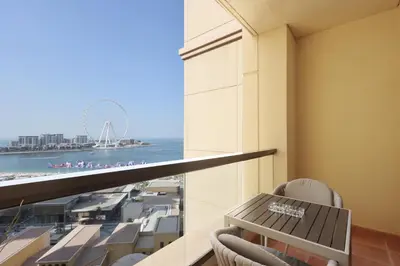 a balcony with a table and chairs and a view of the beach at Upgraded 1B with Beach Access and Ain Dubai Views in Dubai