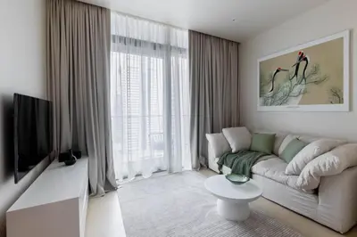 a living room with a couch and a tv at Cosy Apartment Marina Gate in Dubai