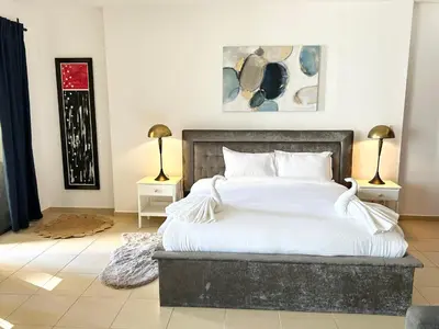 a bedroom with a bed with white sheets and two lamps at Breathtaking Sea and Palm View Spacious Studio with Vibrant Vibes in JBR By SWEET HOMES in Dubai