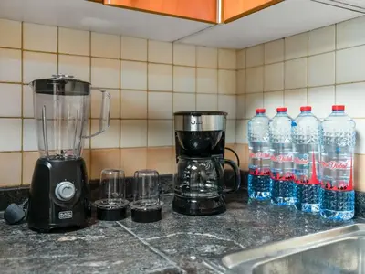 a blender and bottles of water on a kitchen counter at Spacious Home in the heart of Marina w Seaview in Dubai