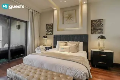 a large bedroom with a large bed and a bench at Higuests - Luxurious 2BR Haven in Iconic Palm Jumeirah in Dubai