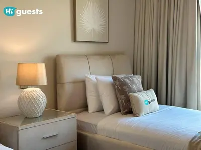 a bedroom with a bed with a lamp and pillows at Higuests - Luxurious 2BR Haven in Iconic Palm Jumeirah in Dubai