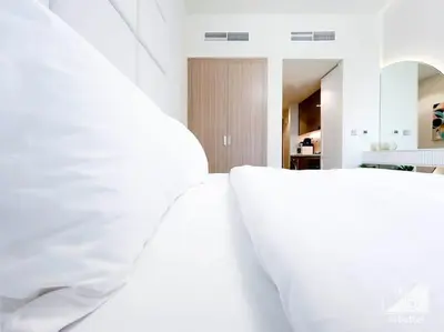 a bedroom with white walls and a white bed at Luxury Living in Azizi Riviera & Cozy Balcony in Dubai