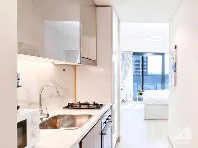 a white kitchen with a sink and a counter top at Luxury Living in Azizi Riviera & Cozy Balcony in Dubai