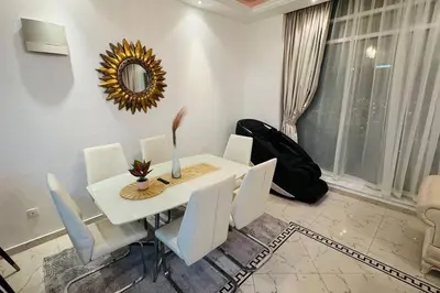 a white dining room table with white chairs and a mirror at Elegant 2BR Apartment in the Heart of Marina in Dubai