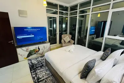 a bedroom with a large white bed and a flat screen tv at Elegant 2BR Apartment in the Heart of Marina in Dubai