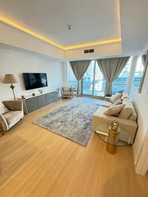 a large living room with a couch and a tv at Bel appartement Dubai marina in Dubai