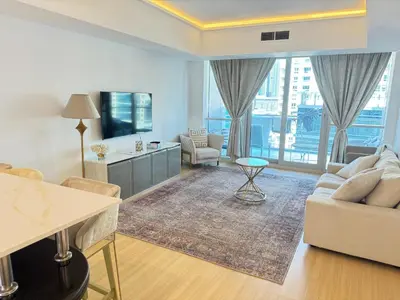 a living room with a couch and a tv at Bel appartement Dubai marina in Dubai