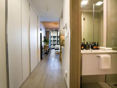 a hallway with a bathroom with a sink and a mirror at EasyGo - Modern STU- Luma22- JVC in Dubai