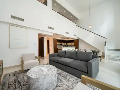 a living room with a couch and a table at Elegant 2 Bed Downtown Duplex - Prime Location in Dubai