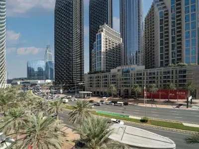 a city street with palm trees in front of tall buildings at Elegant 2 Bed Downtown Duplex - Prime Location in Dubai