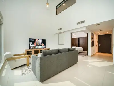 a living room with a couch and a bed at Elegant 2 Bed Downtown Duplex - Prime Location in Dubai