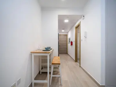 a small kitchen with a table and a hallway at Bright JVC Studio - Serenity Escape in Dubai