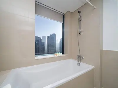 a bathroom with a bath tub and a window at Luxury Downtown 3 Bed with Full Burj Khalifa Views in Dubai