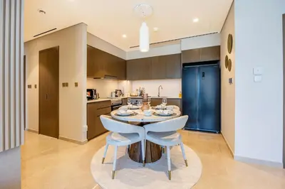 a kitchen with a table and chairs in a room at New 2 Bedroom apartment overlooking Burj Khalifa and fountain view in downtown in Dubai