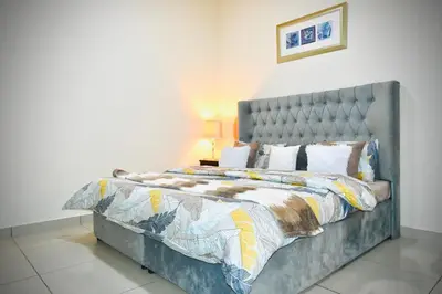a bedroom with a large bed with a gray headboard at Marina Breeze Residence Near to Yachts and Beach in Dubai