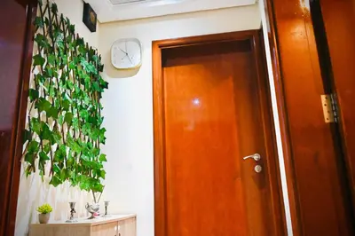 a hallway with a door and a clock on the wall at Marina Breeze Residence Near to Yachts and Beach in Dubai