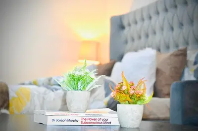 two plants in white vases sitting on a table at Marina Breeze Residence Near to Yachts and Beach in Dubai
