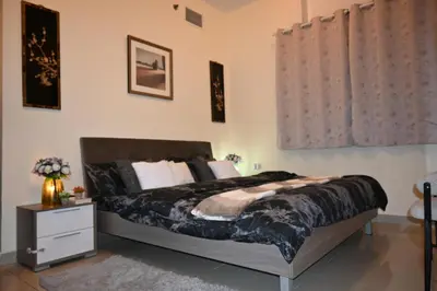 a bedroom with a large bed and a night stand at Marina Breeze Residence Near to Yachts and Beach in Dubai