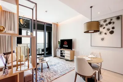 a living room with a table and chairs and a tv at Stunning 1BR with Marina View And Beach Access in Dubai