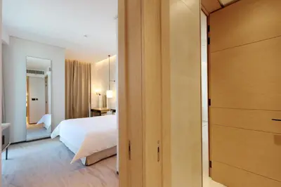 a bedroom with a white bed and a dressing room at Stunning 1BR with Marina View And Beach Access in Dubai