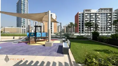a playground in a park with tall buildings at PREMIER 1BR - Burj Khalifa View in Dubai