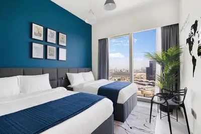 a hotel room with two beds and a large window at Arthouse Grande Signature - 2 BR with Full Burj Khalifa and Fountain View in Dubai