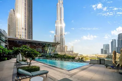 a pool on the roof of a building with a city skyline at Arthouse Grande Signature - 2 BR with Full Burj Khalifa and Fountain View in Dubai
