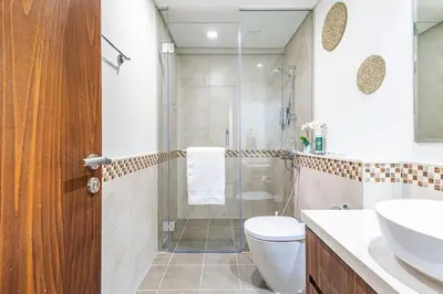 a bathroom with a shower and a toilet and a sink at Elegant 2 Bedroom in Business Bay with Burj View in Dubai