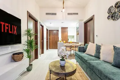 a living room with a green couch and a tv at Elegant 2 Bedroom in Business Bay with Burj View in Dubai