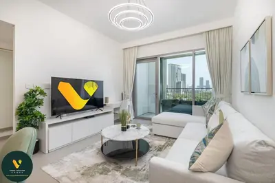 a living room with a couch and a tv at Vogue Downtown Views II with Direct Access to Dubai Mall Via a Climate Controlled Bridge, One Bedroom Apartment with Balcony and City View in Dubai