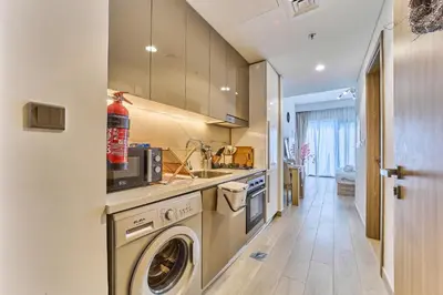 a kitchen with a washing machine and a sink at Chic Studio in Azizi Riviera with Modern Amenities in Dubai