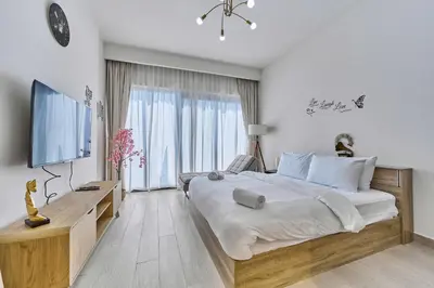 a bedroom with a large bed and a large window at Chic Studio in Azizi Riviera with Modern Amenities in Dubai