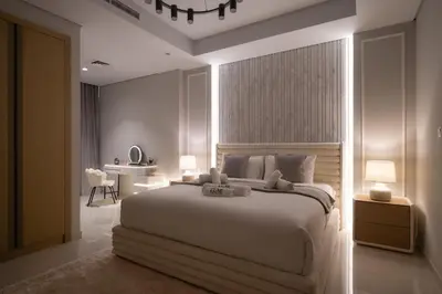 a bedroom with a large white bed and a table at Paramount Midtown by Luxe Living in Dubai