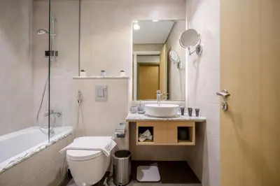 a bathroom with a toilet and a sink and a tub at Paramount Midtown by Luxe Living in Dubai