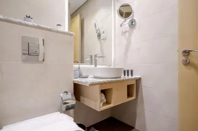 a bathroom with a sink and a mirror at Paramount Midtown by Luxe Living in Dubai