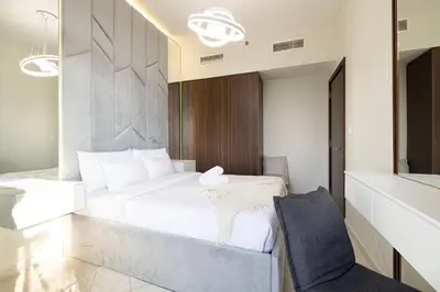 a bedroom with a large white bed and a chair at Burj Khalifa View 1 Bedroom Apartment With Balcony For Up To 4 Person in Dubai