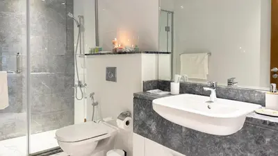 a bathroom with a sink and a toilet and a shower at Canal-View Duplex in Dubai