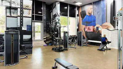 a gym with tread machines and a poster of a man at Canal-View Duplex in Dubai