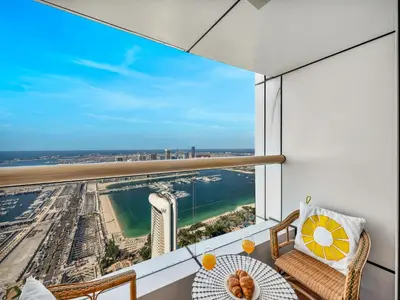 a balcony with a view of the city and the ocean at Iconic Palm & Sea Views on 58th Floor Skyline Apt in Dubai