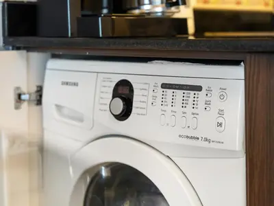 a washing machine with a microwave on top of it at Iconic Palm & Sea Views on 58th Floor Skyline Apt in Dubai