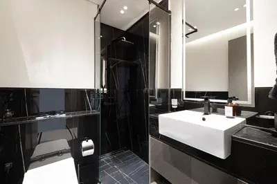 a bathroom with a white sink and a shower at Luxury 2BR Burj View & Jacuzzi in Dubai